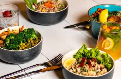 A vibrant assortment of healthy bowls and drinks showcasing fresh ingredients like broccoli and citrus.